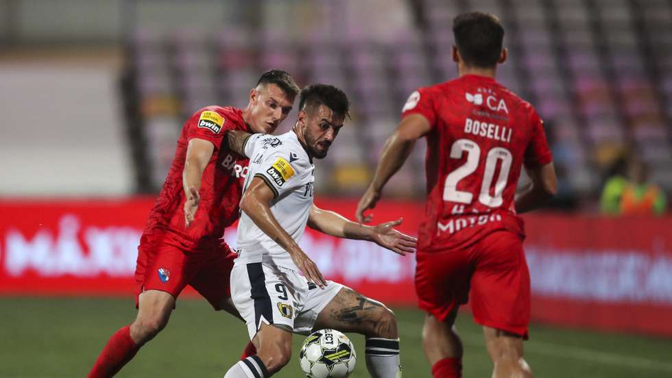 O jogador do Gil Vicente, Marin (E), disputa a bola com o jogador do Famalicão, Millan (C), durante o jogo da Primeira Liga de Futebol, no estádio Cidade de Barcelos, 22 de agosto de 2022. JOSÉ COELHO/LUSA