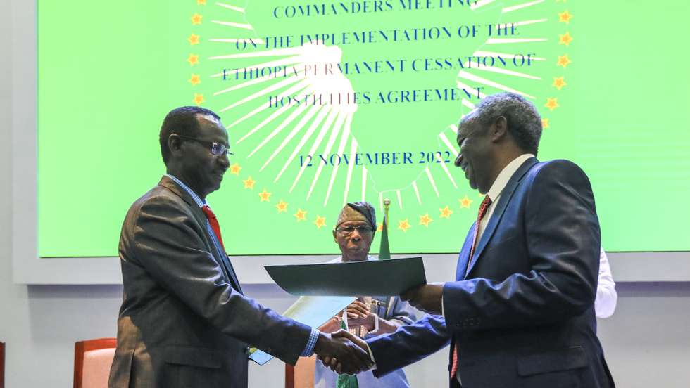 epa10301980 The Military Chief for the Tigray People’s Liberation Front (TPLF) General Tadesse Werede (R) and Chief of the Ethiopian Army Marshal Birhanu Jula (L), exchange signed documents of the peace agreement after peace talks during the signing ceremony of the declaration of the senior commanders meeting on the implementation of the Ethiopia cessation of hostilities agreement after days of peace talks, in Karen, Nairobi, Kenya, 12 November 2022. The Commanders meeting is being facilitated by the African Union (AU) High Representatives for the Horn of Africa and among them is the former President of Nigeria Olusegun Obasanjo, together with AU High-level panel member, former President of Kenya Uhuru Kenyatta.  EPA/DANIEL IRUNGU