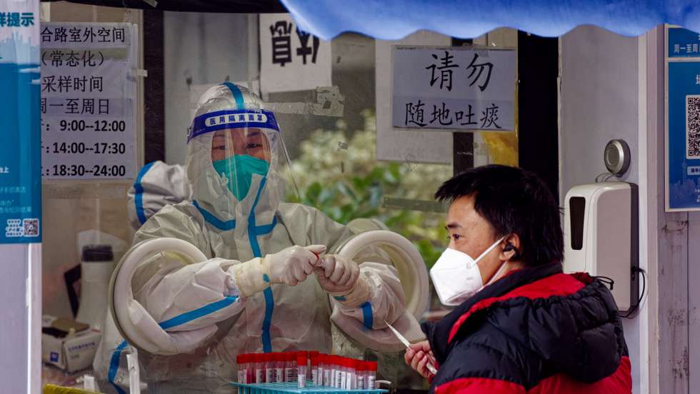 epa10365069 A man takes Coronavirus PCR test in the street testing booth, in Shanghai, China, 14 December 2022. China will no longer report asymptomatic cases of Covid-19 in its daily report, according to the National Health Commission announcement on 14 December. With easing Covid-19 restrictions, a rising number of infections is circulating in Shanghai. This year the holiday season is decorated with people staying at home recovering from the virus. Shopping malls and restaurants are mostly empty, while people can be seen on the streets in the morning before and in the evening after work.  EPA/ALEX PLAVEVSKI