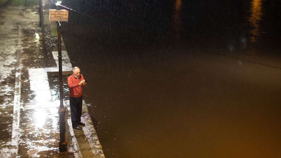 Um popular observa a subida do nivel das águas no rio Tâmega, em Chaves, 19 de dezembro de 2019. Em Chaves, durante a tarde o rio Tâmega galgou as duas margens, obrigando ao encerramento de dois parques de estacionamento e de vias de acesso à zona ribeirinha.  PEDRO SARMENTO COSTA/LUSA