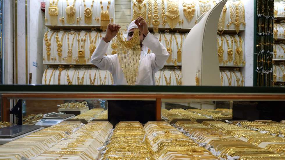 epa12033610 A shop exhibitor shows a gold ornament to a customer at a jewellery shop inside the gold market in Dubai, United Arab Emirates, 15 April 2025. Gold prices rose on 15 April despite uncertainty over the US president's tariff plans and the possible impact on the economy globally.  EPA/ALI HAIDER