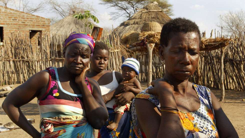 Family members of a woman with AIDS pose for a photo outside the woman's hut 05 November in Cachembe village. Most people with AIDS in villages wait until they are very sick to go to hospital. A group of mothers gather at a community meeting under a Baobab tree in the center of the village of Cachembe 05 November 2003. Cachembe school has 1000 students and  200 of them are orphans. Mozambican President Joaquim Chissano last week asked Brazil for aid to help his southern African country combat a devastating HIV/AIDS epidemic. Chissano said that the proposed construction by Brazilian firms of a pharmaceutical laboratory in Mozambique to produce generic AIDS drugs would have the full backing of his government.   AFP PHOTO ALEXANDER JOE