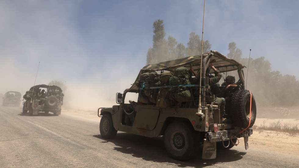 epa12118914 Israeli soldiers on military vehicles move towards the southern Gaza Strip border near Khan Yunis, seen from southern Israel, 20 May 2025. Israel's military continued to strike targets across the Gaza Strip as part of its 'Gideon's Chariots' operation.  EPA/ATEF SAFADI
