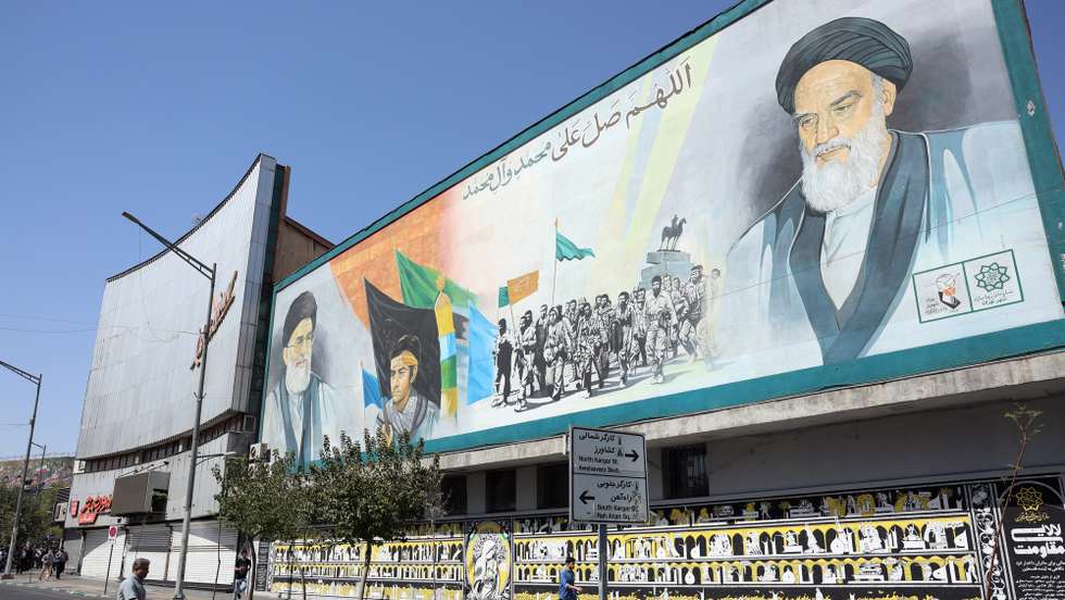 epa12389157 Iranians walk past a huge wall painting depicting the late Iranian supreme leader Ayatollah Ruhollah Khomeini (top-R) and Iranian supreme leader Ayatollah Ali Khamenei (top-L) in Tehran, Iran, 19 September 2025.  EPA/ABEDIN TAHERKENAREH