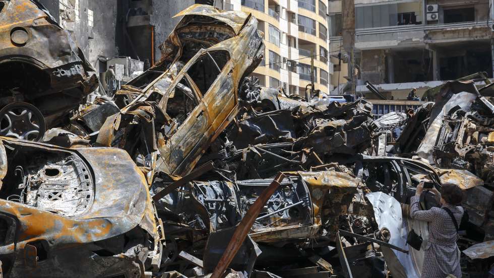 epa12887072 A woman photographs the wreckage of cars in Corniche el Mazraa, one of the areas hit during a massive wave of Israeli airstrikes on 08 April, in Beirut, Lebanon, 13 April 2026. According to the Lebanese Ministry of Public Health, Israeli attacks across Lebanon have killed at least 2,055 people and injured more than 6,588 others since the start of renewed hostilities between Israel and Hezbollah on 02 March 2026.  EPA/WAEL HAMZEH