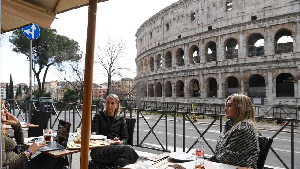 epa08979802 Customers seated at tables outside a cafe eat lunch front a Coliseum in Rome, Italy, 01 February 2021. As many as 293,000 bars, restaurants, pizzerias and agritourism that survived the closures in the regions now classified in the yellow zone were reopened for table or counter service. Regions have entered the yellow zone with the lowest level of restrictions as of 01 February. In yellow zones, shops are allowed to open and restaurants and bars can serve customers until 6pm, after which time they can only do takeaway and delivery services.  EPA/MASSIMO PERCOSSI