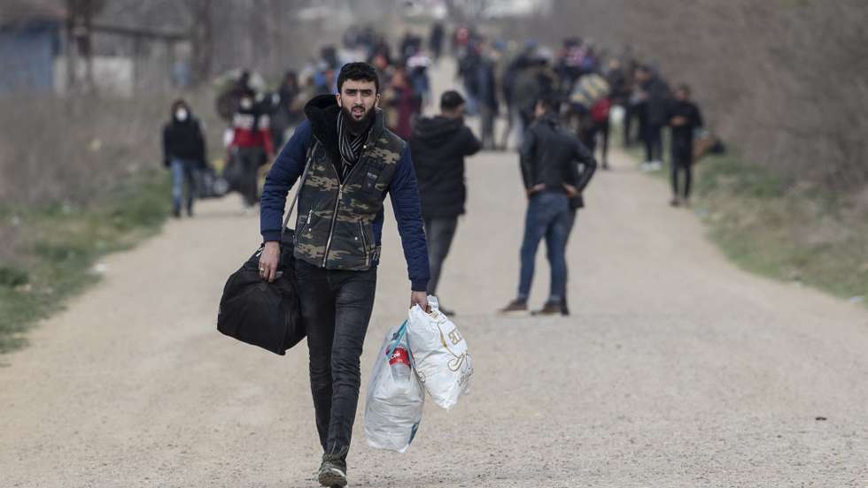 epa08282626 A migrant carrying his belongings walks along the Turkish-Greek border, near the Pazarkule border gate, in Edirne, Turkey, 10 March 2020. Some 10,000 migrants, mostly from Syria, have reached Turkey's land borders with Greece and Bulgaria with the intention of crossing into the European Union. Greek security forces have reportedly used tear gas to stop them from crossing, media reported.  EPA/TOLGA BOZOGLU