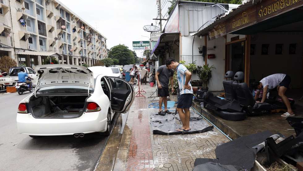epa13282417 Thai residents clean the carpet and seats of a flood-damaged car after floodwaters receded at Khlong Chan Flats community in Bangkok, Thailand, 05 October 2026. Massive floods triggered by persistent heavy rain caused flooding across Bangkok, affecting around 329,000 households and 700,000 people and leaving four people dead, according to the Department of Disaster Prevention and Mitigation.  EPA/RUNGROJ YONGRIT