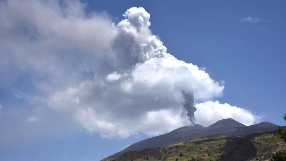 epaselect epa13141394 A plume of ash and smoke billows from the Voragine crater of Mount Etna, seen from Catania, Sicily, Italy, 30 July 2026. The volcanic activity in the Voragine crater has gone from 'Strombolian' to 'lava fountain,' resulting in the emission of incandescent magma fragments that fell into the volcano's summit area.  EPA/ORIETTA SCARDINO