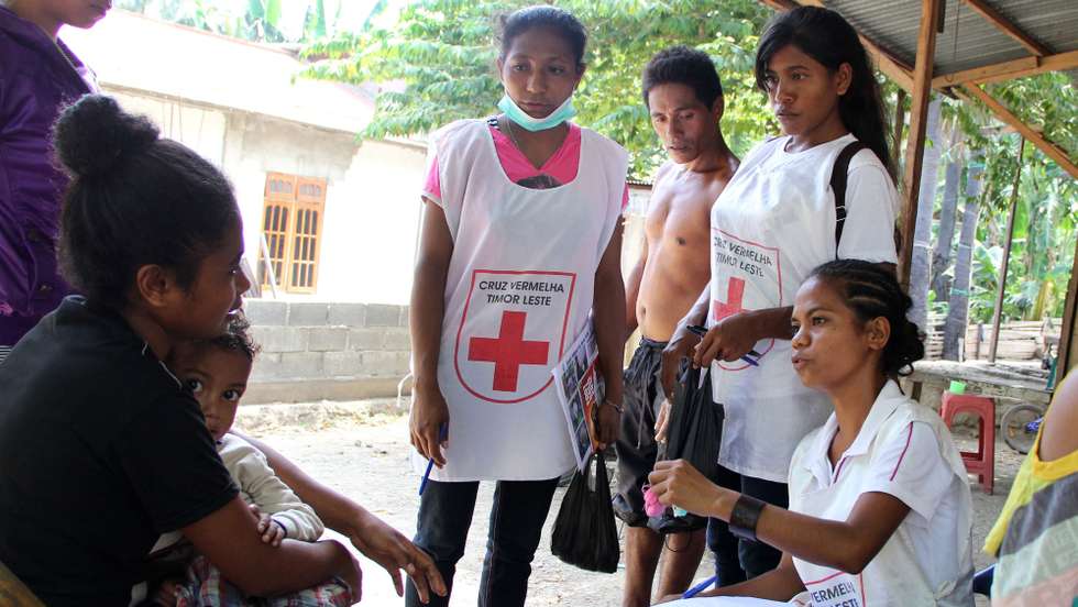 Voluntários da Cruz Vermelha conversam com uma moradora de um dos bairros de Díli, no âmbito da campanha para prevenção do dengue, numa luta que se faz essencialmente pela mudança de mentalidade das pessoas e pela partilha de informação