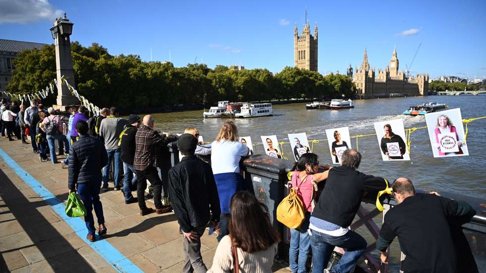 epa10230688 Supporters of Wikileaks founder Julian Assange form a human chain around the British parliament in London, Britain, 08 October 2022. The British government has announced it has agreed to extradite Assange to the United States.  EPA/ANDY RAIN