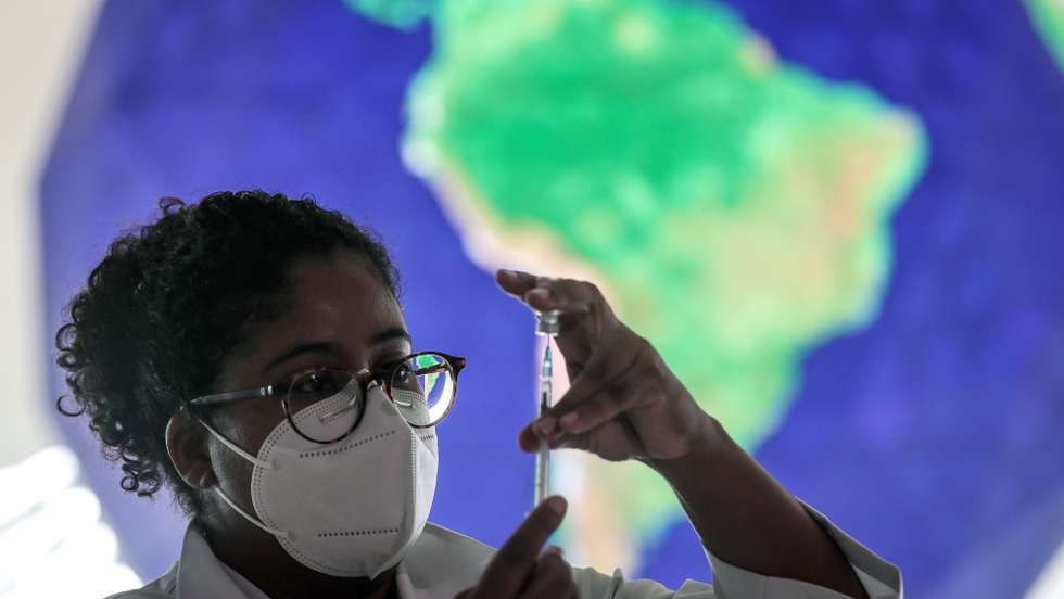 Uma profissional de saúde com uma vacina da Covid-19 no Brasil