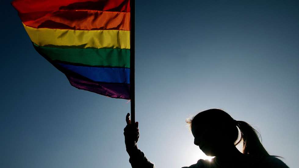 epa02795882 A woman holds a rainbow flag as members of the 'Movement of Homosexual Integration and Liberation' (MOVILH) and other activists march through the streets to claim sexual diversity and equality for sexual minorities before the law, Santiago, Chile, on 25 June 2011.  EPA/FERNANDO NAHUEL