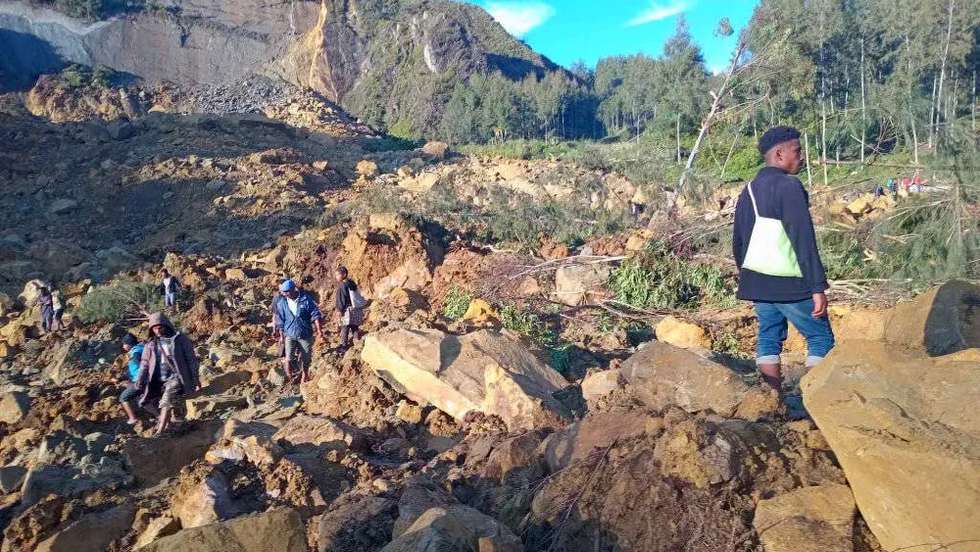 epa11365145 People walk with their belongings in the area where a landslide hit the village of Kaokalam, Enga province, Papua New Guinea, 24 May 2024. A landslide reportedly killed about 100 people in a remote village of northern Papua New Guinea.  EPA/NINGA ROLE  BEST QUALITY AVAILABLE AUSTRALIA AND NEW ZEALAND OUT  EDITORIAL USE ONLY  EDITORIAL USE ONLY