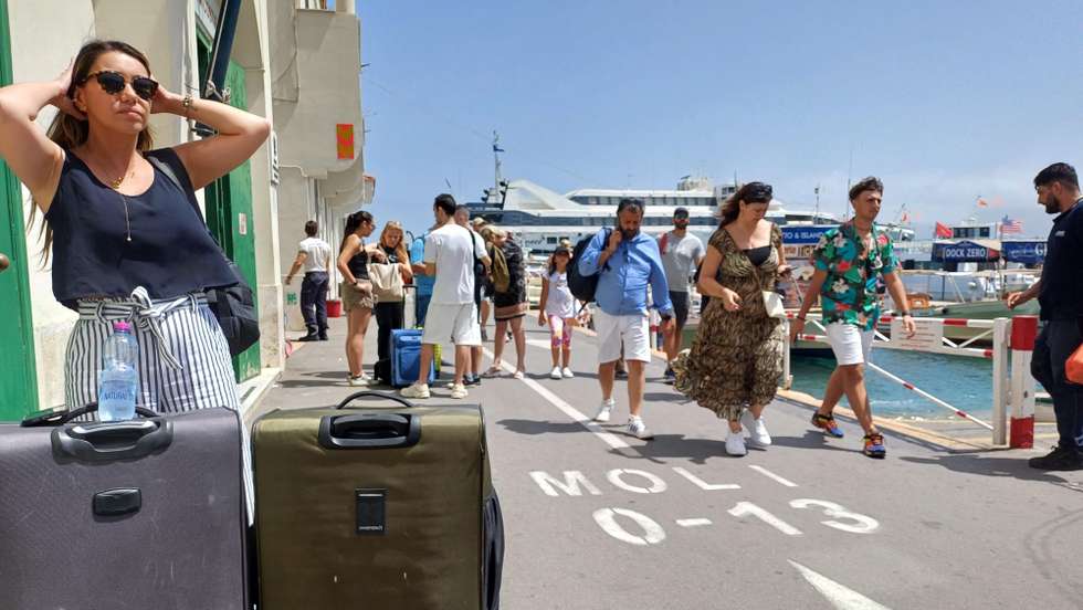 epa11429930 People walk on a pier in a port in Capri Island, Italy, 22 June 2024. The mayor of Capri, Paolo Falco, issued a decree on June 22 restricting the arrival of tourists to the island due to the failure of the water pipe that supplies the island. The failure left the island with only local reservoirs of water. Residents of Capri are allowed to disembark boats and ferries heading to the island.  EPA/GIUSEPPE CATUOGNO