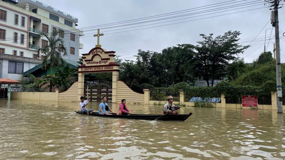 epa10911726 People travel by boat along a flooded street in Bago, Myanmar, 10 October 2023. Heavy monsoon rains have caused floods and landslides in Myanmar.  EPA/NYEIN CHAN NAING