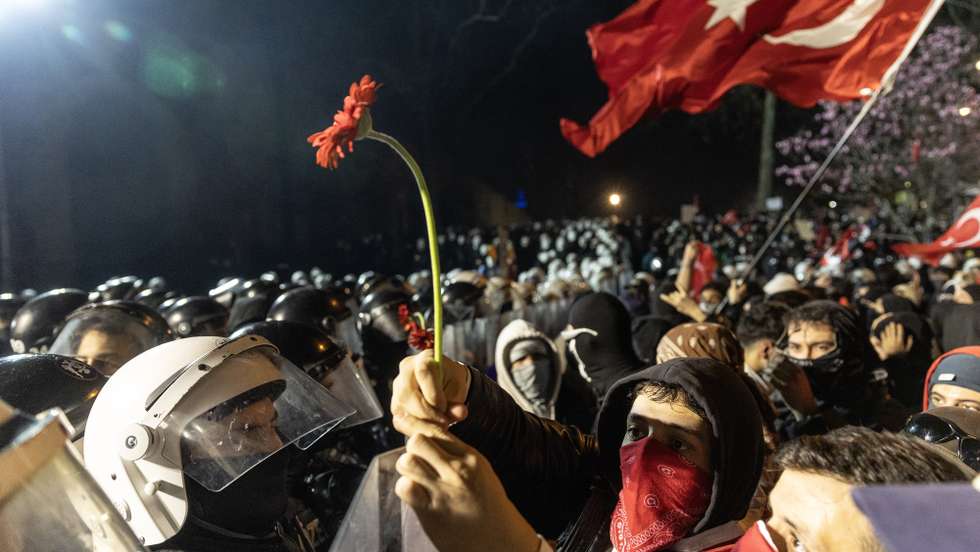 epaselect epa11986042 A protester holds a flower towards policemen during a march to Taksim Square from the Istanbul Municipality headquarters during a protest against the detention of Istanbul Mayor Ekrem Imamoglu in Istanbul, Turkey, 24 March 2025. Istanbul Mayor Ekrem Imamoglu of the Republican People's Party (CHP) was jailed and dismissed by the Turkish Ministry of Interior on 23 March on corruption charges following his detention on March 19 along with 100 others.  EPA/ERDEM SAHIN