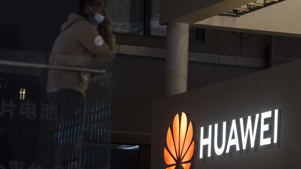 epa09148983 A man stands in front of the Huawei trade fair stand during the first day of the Auto Shanghai 2021 motor show in Shanghai, China, 21 April 2021. The 19th International Automobile Industry Exhibition runs from 24 to 28 April.  EPA/Alex Plavevski