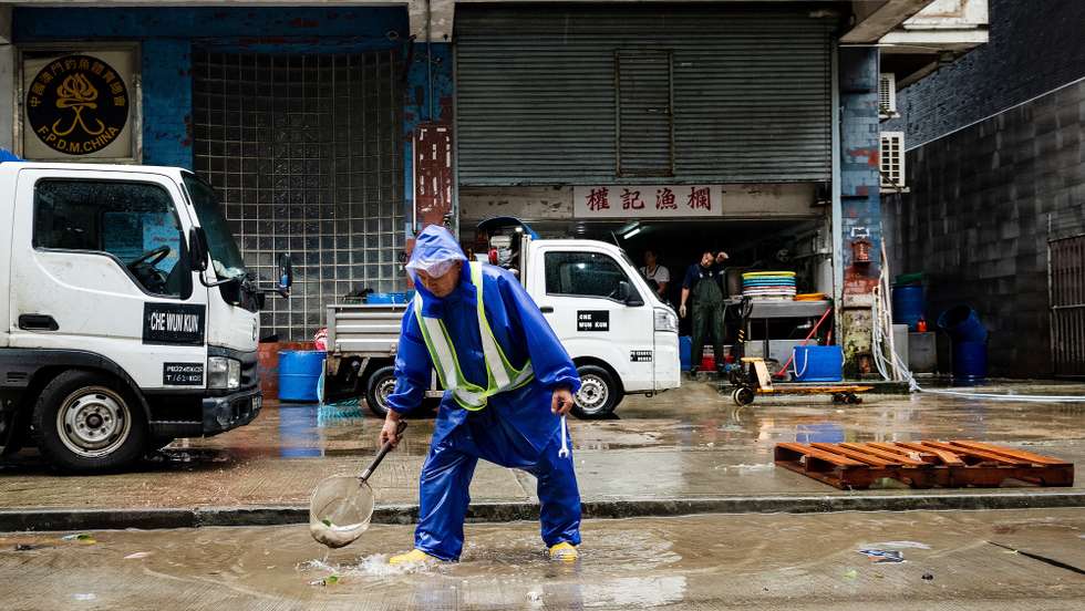 epa08612359 A city worker collects debris from the street after Tropical storm Higos had passed very close to Macao, China, 19 August 2020. Higos is now 100 kilometers northwest of Macau and 'is gradually moving away' from the territory.  EPA/TATIANA LAGES