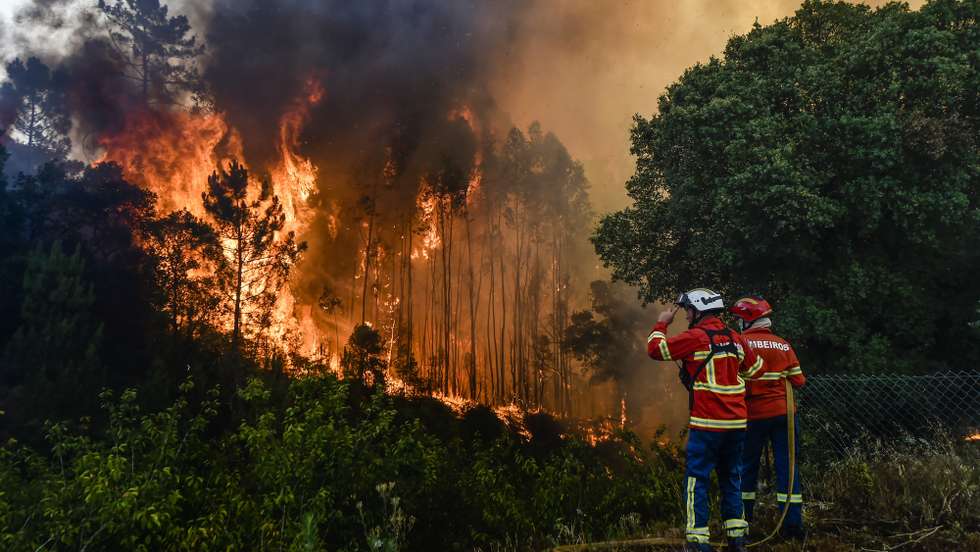 Elementos dos bombeiros durante o combate ao incêndio florestal na aldeia do Lavradio, Ourém, 13 de julho de 2022. Dezasseis dos 18 distritos de Portugal continental estão hoje sob aviso vermelho, o mais grave, devido ao tempo quente, com mais de uma centena de concelhos em perigo máximo de incêndio rural. NUNO ANDRÉ FERREIRA/LUSA