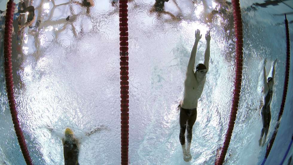 epa01451752 US swimmer Michael Phelps second from R, Australian Andrew Lauterstein (L) and Takuro Fujii from Japan (R)  competes in the butterfly leg of the men's 4 X 100m medley relay at the National Aquatic Center at the Beijing 2008 Olympic Games, Beijing, China, 17 August 2008. Phelps won his eighth Beijing Olympics gold medal with the teams win which also set a new world record of 3:29.34 allowing Phelps to surpass Mark Spitz's 1972 Munich games record of seven.  EPA/PATRICK B. KRAEMER