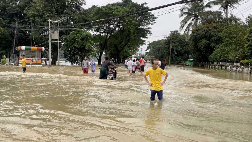 epa10909520 People wade through the flood in Bago, Myanmar, 09 October 2023. Storms and monsoon rains have caused floods and landslides in Myanmar.  EPA/NYEIN CHAN NAING