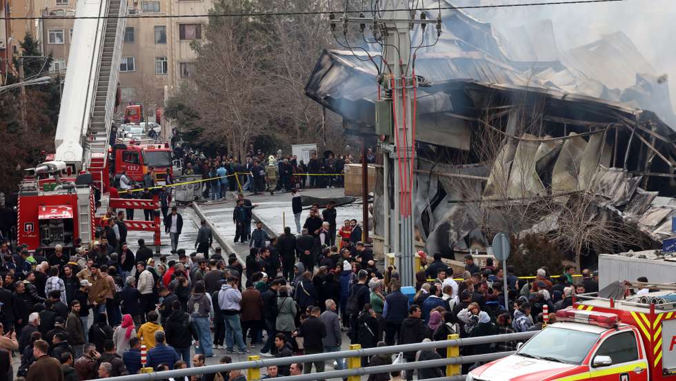 epa12701686 Smoke rises from a fire as people gather around Jannat shopping market in western Tehran, Iran, 03 February 2026. The cause of the fire is unclear.  EPA/ABEDIN TAHERKENAREH
