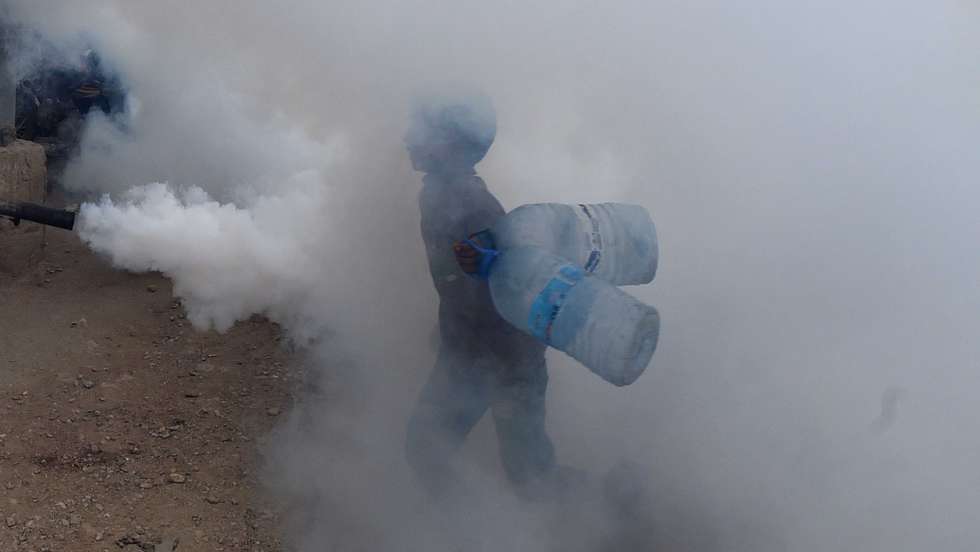 epa11623818 A boy walks amid fumigation spray during a campaign conducted by Al-Khidmat foundation in Karachi, Pakistan, 26 September 2024. In response to growing concerns over mosquito-borne diseases such as chikungunya and dengue, the Al-Khidmat Foundation in Karachi has initiated fumigation efforts aimed at eradicating mosquito breeding grounds.  EPA/SHAHZAIB AKBER