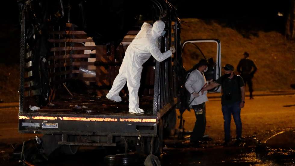 epa09672825 Members of the Colombian National Police examine the site of the attack on a national police truck in Cali, Colombia, 08 January 2022. An attack carried out with explosives against a police truck in Cali, the main city in southwestern Colombia and the capital of the Valle del Cauca department, left at least 10 injured, local authorities reported. The Mayor of the city, Jorge Ivan Ospina, condemned what happened in a sector known as Puerto Rellena, which was one of the epicenters of the 2021 protests against President Ivan Duque's Government.  EPA/ERNESTO GUZMAN JR