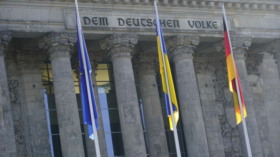 epa09788459 The Ukrainian flag (C) hangs in front of the German parliament 'Bundestag' in Berlin, Germany, 27 February 2022. German Chancellor Olaf Scholz is expected to explain himself after a change of course in the Ukraine crisis. The German government on 26 February 2022 decided to deliver anti-tank weapons, Stinger anti-aircraft defense systems and howitzers.  EPA/CLEMENS BILAN