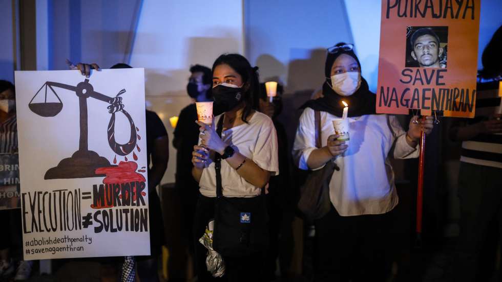 epa09910125 Activists hold placards and candles during a candlelight vigil against the death penalty for Malaysian national Nagaenthran K. Dharmalingam, who was convicted of a drug offence 11 years ago in Singapore but diagnosed as intellectually disabled, outside Singapore's embassy in Kuala Lumpur, Malaysia, 26 April 2022. Nagaenthran K Dharmalingam's mother filed a a last-minute legal challenge on 25 April to halt her son's execution and to set aside his conviction, her challenge was dismissed by the Singapore Court of Appeal on 26 April, and he is scheduled to be executed on 27 April 2022 in Singapore.  EPA/FAZRY ISMAIL