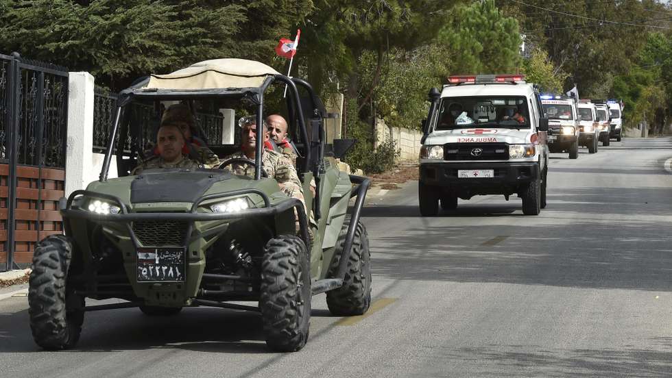 epa10925658 Lebanese army soldiers lead a convoy of Lebanese Red Cross ambulances transporting the bodies of four Hezbollah fighters who were killed during clashes on the Lebanese-Israeli border, in the town of Alma al-Shaab, southern Lebanon, 18 October 2023. Tensions remain high on the Lebanon-Israel border following an escalation in fighting between the two countries as the Israeli-Palestinian conflict flared up.  EPA/WAEL HAMZEH