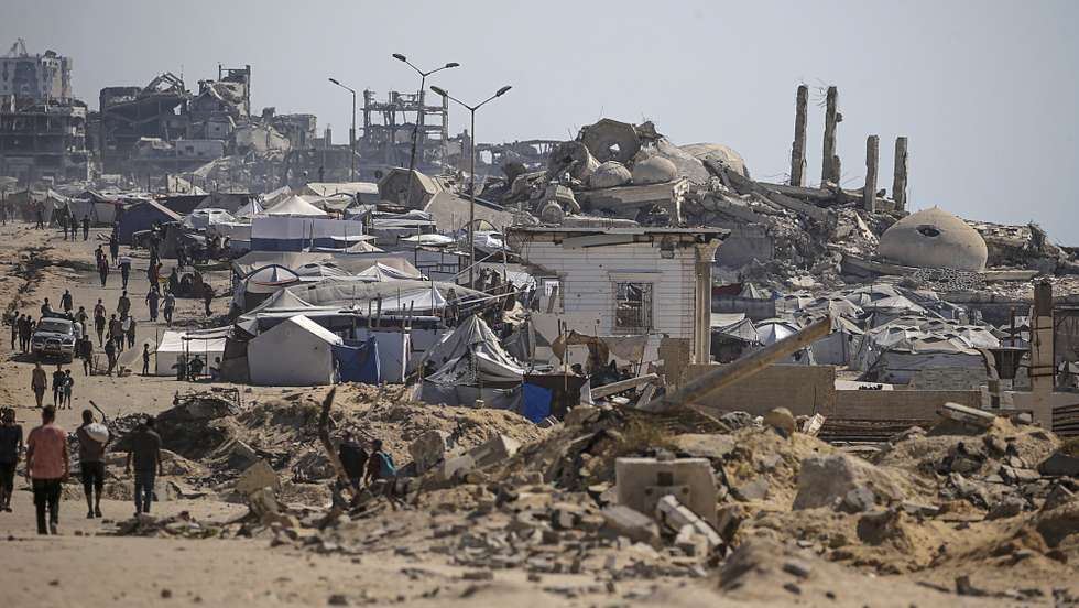 epa12249943 Internally displaced Palestinians walk along Rashid Road in western Jabalia, northern Gaza Strip, 20 July 2025. According to the Palestinian Ministry of Health in Gaza, at least 67 people were killed while trying to receive humanitarian aid in the Zikim area, northern Gaza.  EPA/MOHAMMED SABER