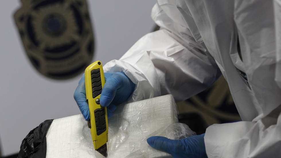 Um agente da Polícia Judiciária (PJ) na apresentação da apreensão de cocaína suficiente para 1,7 milhões de doses, durante a realização da operação “White-wing”, em Lisboa, 12 de outubro de 2020. A  Polícia Judiciária deteve cinco homens por suspeitas de integrarem uma organização criminosa transnacional dedicada ao tráfico de droga que recorria a voos privados e apreendeu . Foi igualmente apreendida “uma aeronave, um jato bimotor, que foi utilizada no transporte da droga a partir da América Latina. ANTÓNIO COTRIM/LUSA