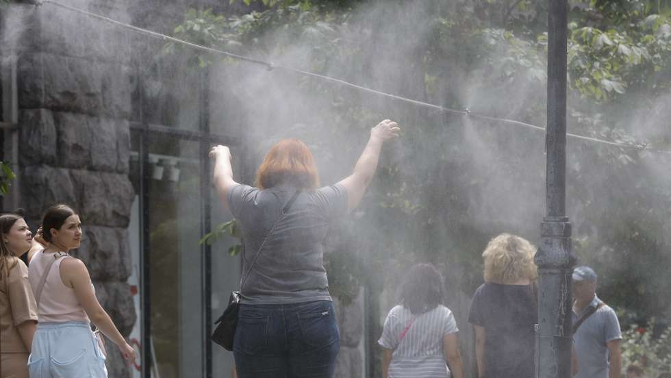 epa11459161 Ukrainians cool themselves with water sprayed from pipes hanging over a sidewalk at the central street of Khreshchatyk during hot weather last days in Kyiv, Ukraine, 05 July 2024. According to weather forecast reports, temperatures will reach 33-36 degrees Celsius next week in the Ukrainian capital.  EPA/SERGEY DOLZHENKO 57120