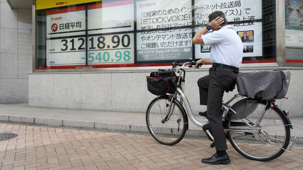 epaselect epa10896731 A man sitting on bicycle looks at a stock market indicator board in Tokyo, Japan, 03 October 2023. Tokyo's Nikkei Stock Average closed lower for a fourth consecutive day amid concerns on the US Federal Reserve interest rates. The yen continued its fall against the US dollar approaching the 150 yen mark for a dollar in the afternoon trading.  EPA/FRANCK ROBICHON
