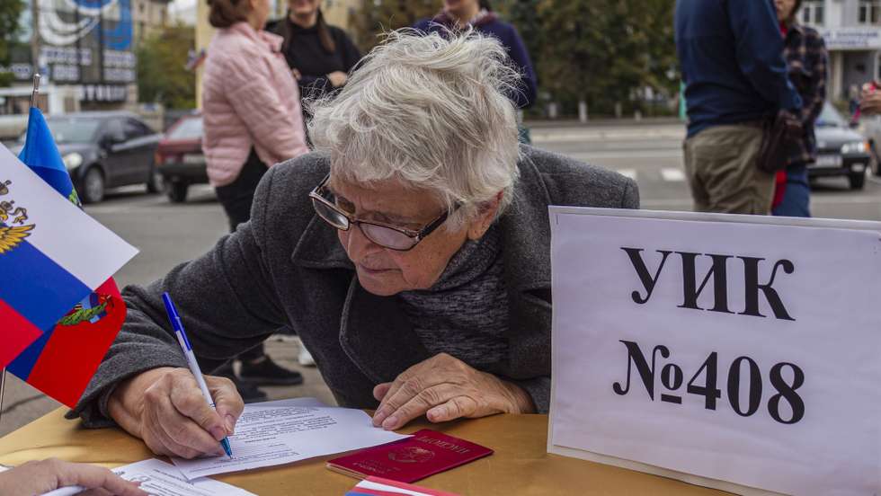 epa10203746 A woman fills up a document during voting in a referendum, at an outdoor polling station in Luhansk, eastern Ukraine, 24 September 2022. From 23 to 27 September, residents of the self-proclaimed Luhansk and Donetsk People's Republics as well as the Russian-controlled areas of the Kherson and Zaporizhzhia regions of Ukraine vote in a referendum to join the Russian Federation. On 24 February 2022 Russian troops entered the Ukrainian territory in what the Russian president declared a 'Special Military Operation', starting an armed conflict that has provoked destruction and a humanitarian crisis.Â   EPA/STRINGER