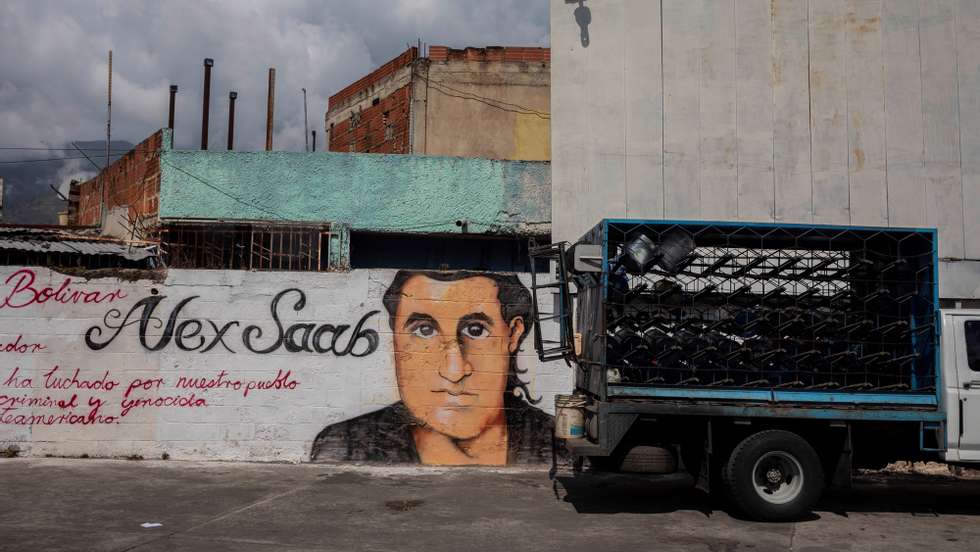 epa09030459 A small truck passes by a graffiti with the image of Alex Saab&#039;s face in Caracas, Venezuela, 22 February 2021. Chavista supporters have painted murals in the Venezuelan capital to show their support and request the release of Alex Saab, a Colombian businessman detained in Cape Verde and whom the United States is asking for extradition by accusing him of being a front man for the president of Venezuela, Nicolas Maduro.  EPA/Rayner Pena