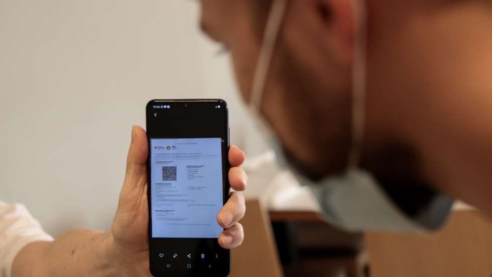 Cliente exibe o certificado digital à entrada de um restaurante em Lisboa, após o Governo decreta que os restaurantes em concelhos de risco elevado ou muito elevado – um total de 60 – passam a ter de exigir certificado digital ou teste negativo à covid-19 a partir das 19:00 de sexta-feira e aos fins de semana para refeições no interior, Lisboa, 10 de julho de 2021. As pessoas em esplanadas que precisarem de entrar nos restaurantes para acesso aos serviços comuns, como instalações sanitárias, ou para efetuarem pagamento, estão dispensadas de apresentar um teste negativo à covid-19 ou o certificado digital. MANUEL DE ALMEIDA/LUSA