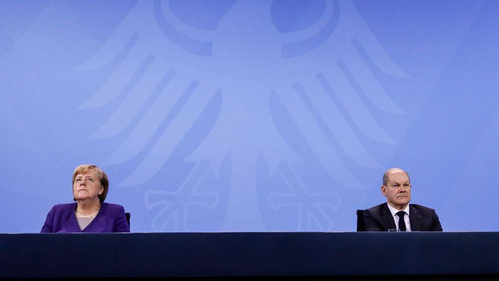 epa09616668 German Chancellor Angela Merkel (L) and Acting German Minister of Finance and Social Democratic Party (SPD) top candidate for the federal elections Olaf Scholz (R) attends a press conference after a video conference with German State Premiers about the current coronavirus situation, at the Chancellery in Berlin, Germany, 02 December 2021  EPA/FILIP SINGER / POOL