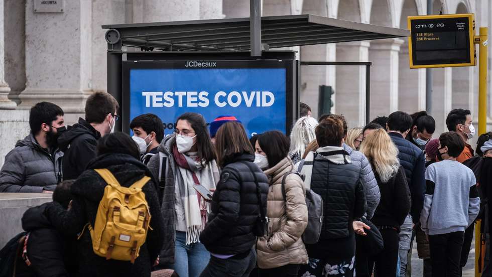 People waiting for a bus next to a sign advertising covid testing in Lisbon, Portugal, 30 December 2021. Yesterday, Portugal registered 26,867 new covid-19 infections, a new high since the start of the pandemic. Due to the surge of positive cases and the rise of the Omicron variant Portugal's government decided to implement restrictive measures such as closing schools, bars and clubs. MARIO CRUZ/LUSA