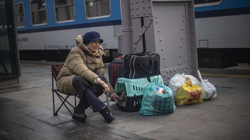 epa09826007 A woman feeds her dog on the platform as people fleeing Ukraine arrive to the main railway station in Prague, Czech Republic, 15 March 2022. According to the Czech Interior Ministry, the country has already granted over 160,000 special long-term visas to Ukrainian citizens fleeing the Russian invasion.  EPA/MARTIN DIVISEK