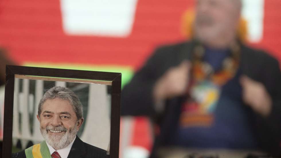 epa09886685 A portrait of former Brazilian President Luiz Inacio Lula da Silva (R-out of focus), who is running in the elections next October, as he participates in a meeting with thousands of indigenous people, whom he urged to participate in the elaboration of his government plan, in Brasilia, Brazil, 12 April 2022. 'I am willing to govern this country again' and 'if that happens, you will have to participate in the elaboration of the government program', Lula declared before thousands of indigenous people. About 8,000 people from 100 traditional towns spend a week camping during the 18th edition of the so-called Terra Livre Camp (ATL) under the theme 'Retake Brazil: Demarcating Territories and People's Policies'.  EPA/Joedson Alves