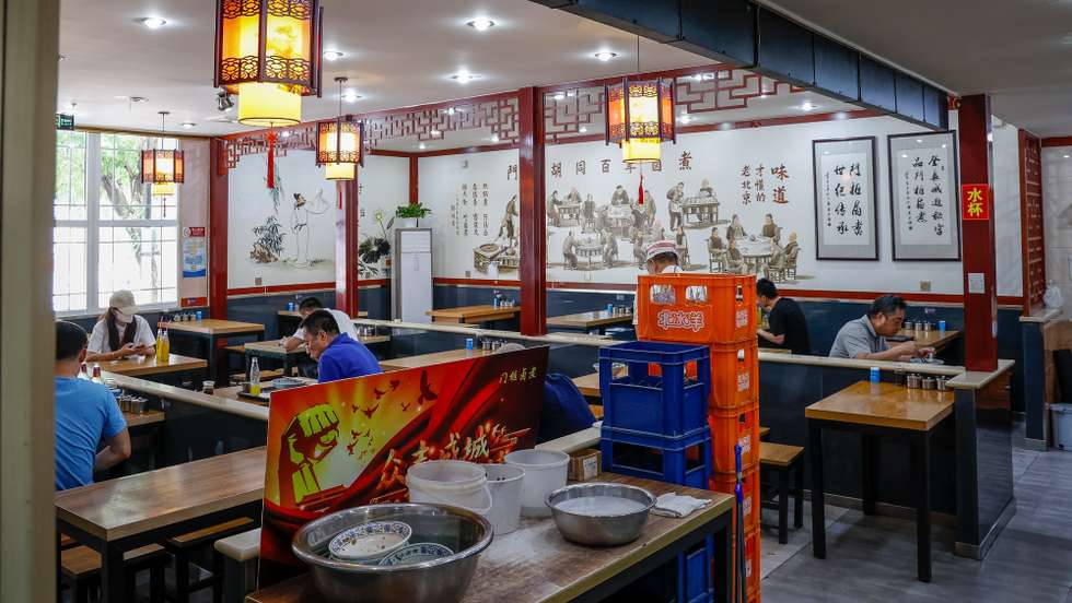 epa09998570 People eat inside a restaurant in Beijing, China, 06 June 2022. Beijing authorities have lifted more COVID-19 restrictions in the city except Fengtai district and some parts of the Changping district. Dine-in services and all public transportation operations resumed services amid requiring a negative COVID-19 result within 72 hours.  EPA/MARK R. CRISTINO