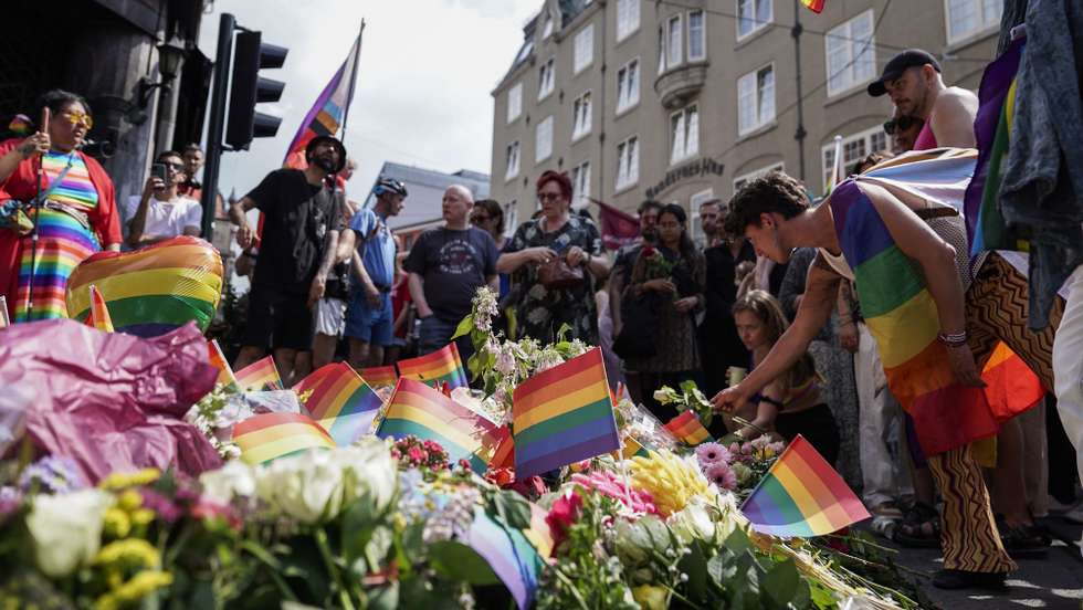epa10033314 Participants in an impromtu pride parade lays flowers and rainbow flags next to a crime scene in the aftermath of overnight shootings in the center of Oslo, Norway, 25 June 2022. Two people were killed and at least 21 were injured when a gunman fired shots outside the London Pub, a gay bar and nightclub, and surrounding areas. The man was detained shortly after and charged with murder and terrorism. The annual Pride Parade and related events in Oslo, scheduled for 25 June, were called off for security reasons.  EPA/Hakon Mosvold Larsen NORWAY OUT