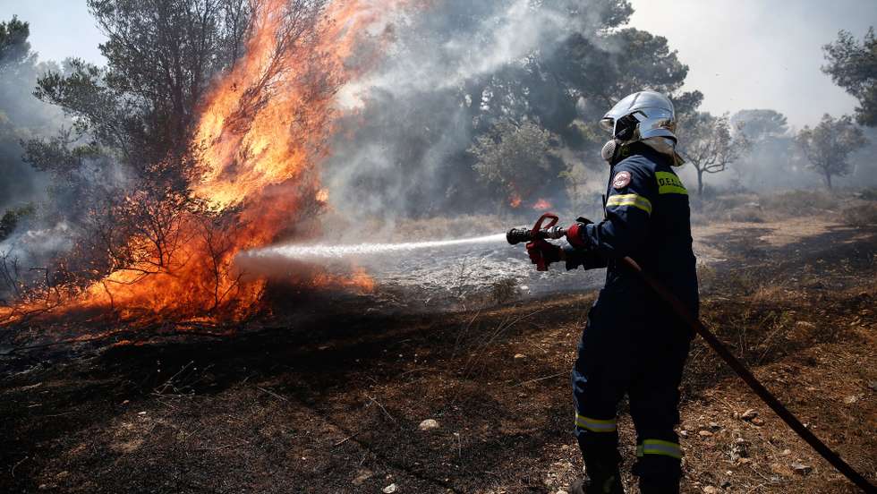 epa10081514 A firefighter tries to put out a forest fire that broke out at the north-east suburb of Pallini, near Athens, Greece, 20 July 2022. Raging wildfires continued to burn throughout the night and into the early morning hours on 20 July in the northeast suburbs of Athens, with fire fighters and civil protection services engaged in a desperate battle to control flames that were fanned by gale-force winds with high speed, intensity and constantly changing direction. The Hellenic Police have carried out 600 evacuations of citizens to safe locations. Three planes and five helicopters joined the battle, alongside 485 firefighters, 120 fire engines and 28 ground teams operating below, assisted by volunteer fire fighters, local authority water tanker trucks and heavy machinery.  EPA/YANNIS KOLESIDIS