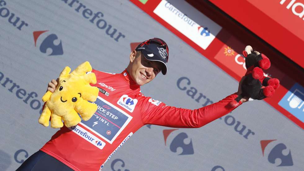 epa10159709 Belgian rider Remco Evenepoel of Quick Step team celebrates on the podium retaining the overall leader's red jersey following the 15th stage of the 77th La Vuelta cycling race over 152.6km from Martos to Alto Hoya de la Mora (Sierra Nevada), Spain, 04 September 2022.  EPA/Javier Lizon