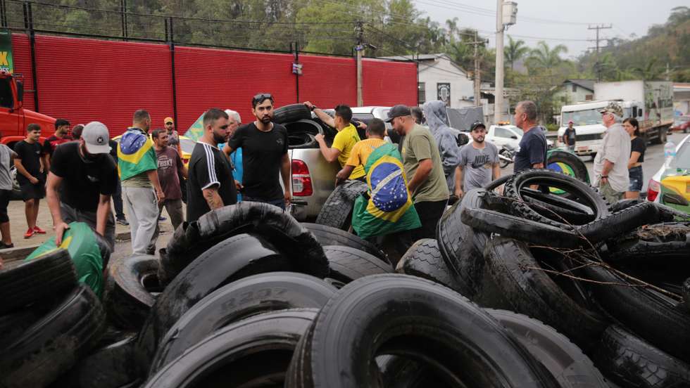 epa10277646 Supporters of Jair Bolsonaro carry out a blockade to protest against the results of the presidential elections, at kilometer 76 of the RJ 116 highway near Nova Friburgo, Brazil, 31 October 2022. The Bolsonaro protesters blocked dozens of highways in Brazil 31 October protesting the defeat of Jair Bolsonaro as they believe that there was â€˜fraudâ€™ in Sunday's elections. The blockades, mostly caused by truck drivers, have been registered in at least 70 highway points in twelve states throughout Brazil, according to information from the Federal Police.  EPA/ANDRE COELHO