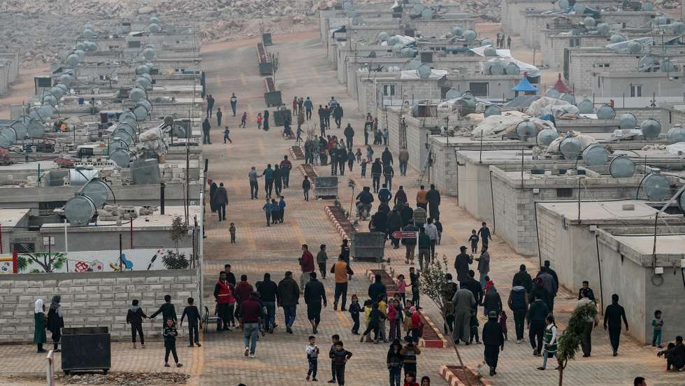 epa09606391 Displaced Syrians walk at Mashad Ruhin Brick House camp in Sarmada district, on the outskirts of Idlib, Syria, 26 November 2021 (issued 27 November 2021). Since 2011, the Turkish Red Crescent (or Kizilay) has delivered 55 thousand trucks of aid materials into Syria. Some 111 thousand tents, eight million food parcels, 116 million bread parcels, 2.7 million hygiene kits, 2.5 million stationery materials, 65 million clothing and blankets have been distributed. Around 20,000 packets of bread are produced daily in Turkish Red Crescent's bakeries and delivered to those in need. Aid materials sent in this context have so far amounted to 3.5 billion Turkish lira (about 281 million US dollar). There are 12 camps and 14 orphanages in the Idlib region. In the Mashat Ruhin region of Idlib's Sarmada district, the Turkish Red Crescent has planned to build 1,228 brick houses, of which, more than 748 have been completed. According to the United Nations UN), 13.4 million people inside Syria are in need of some form of humanitarian assistance, including six million in acute need. More than 12 million were struggling to find enough food each day and half a million children were chronically malnourished.  EPA/SEDAT SUNA