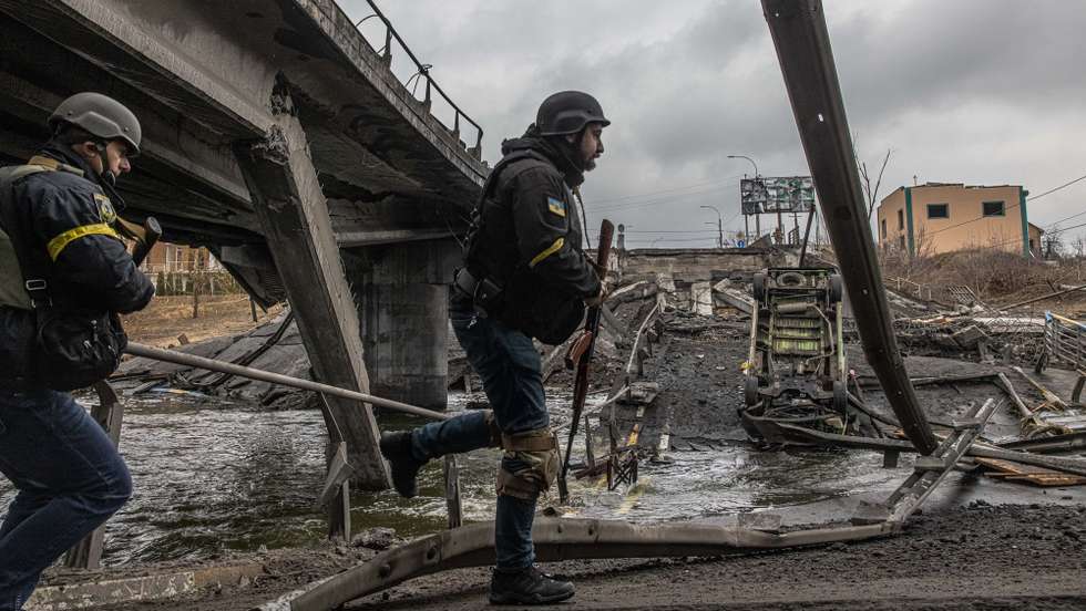 epa09799527 Ukrainian military members walk on a bridge destroyed by shelling in Irpin city, Kyiv (Kiev) province, Ukraine, 03 March 2022. Russian troops entered Ukraine on 24 February prompting the country's president to declare martial law and triggering a series of severe economic sanctions imposed by Western countries on Russia.  EPA/ROMAN PILIPEY